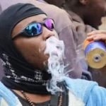 A protester in Kenya smoked tear gas from a canister thrown by police during protests (video).